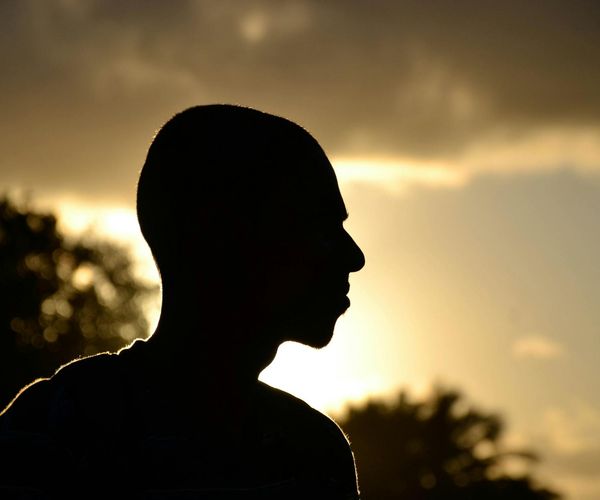Silhouette of a person meditating against a warm, glowing background.