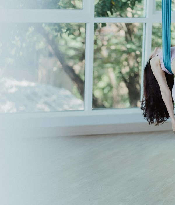 Woman in a calm yoga pose in a warmly lit studio.